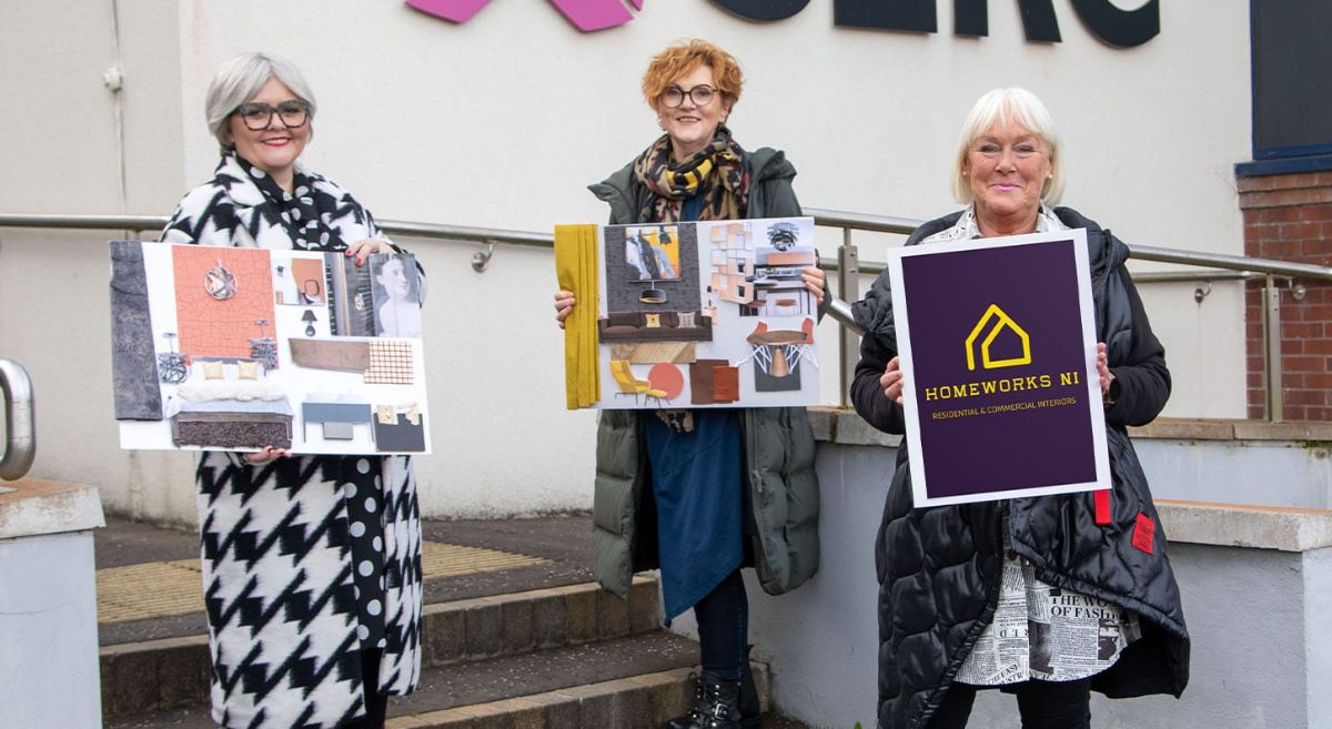 Two students with mood boards pictured with lecturer with HomeWorks branding outside SERC Bangor Campus